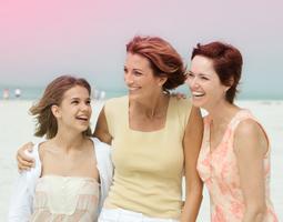 Bilde av 3 kvinner som holder rundt hverandre, en yngre kvinne til venstre og to eldre kvinner til høyre.